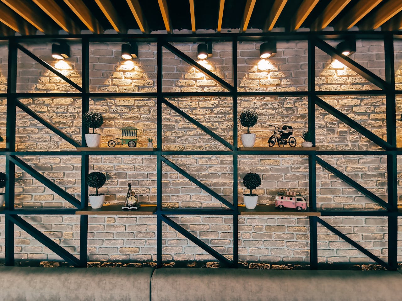 Stylish interior with a brick wall featuring decorative shelves and warm lighting.